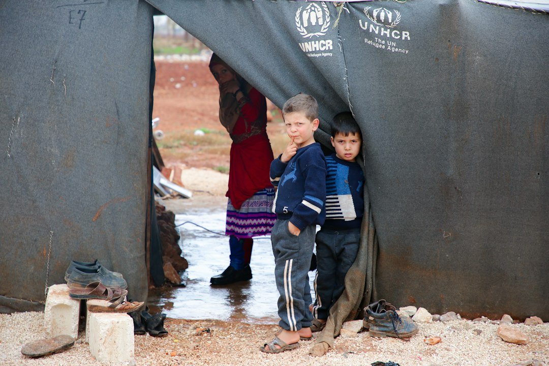 Refugee children standing together; photo by Salah Darwish on Unsplash