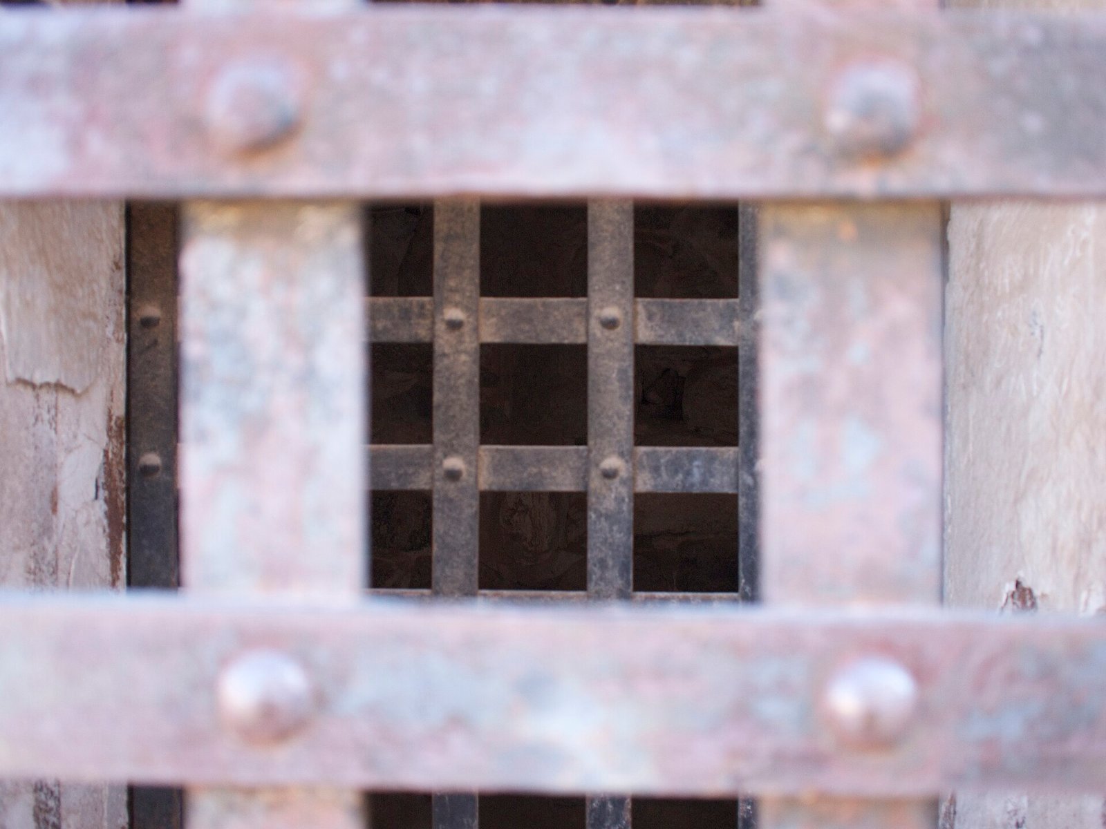 Iron bars and riveted doors of a historic prison cell